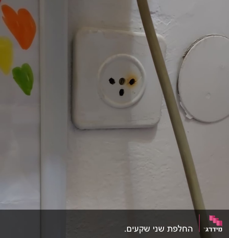 שקע חשמל עם סימני שריפה על הקיר